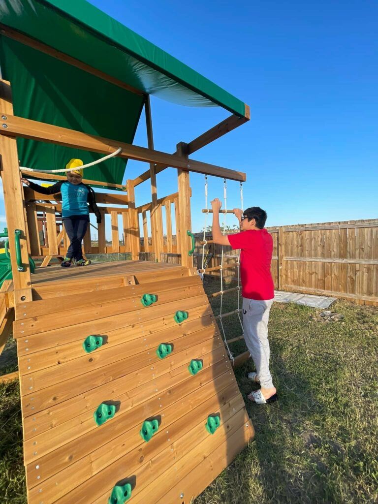 Jose and his older brother, Rafael, playing on their new playset