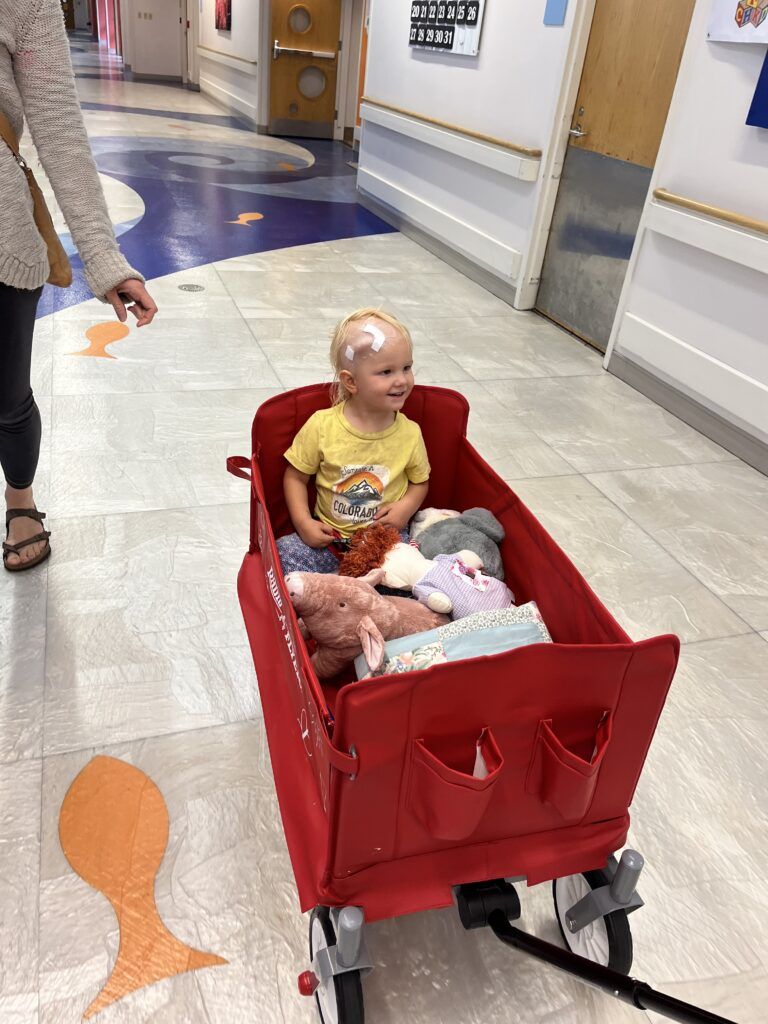 Isla taking ride in her wagon during treatment at the hospital