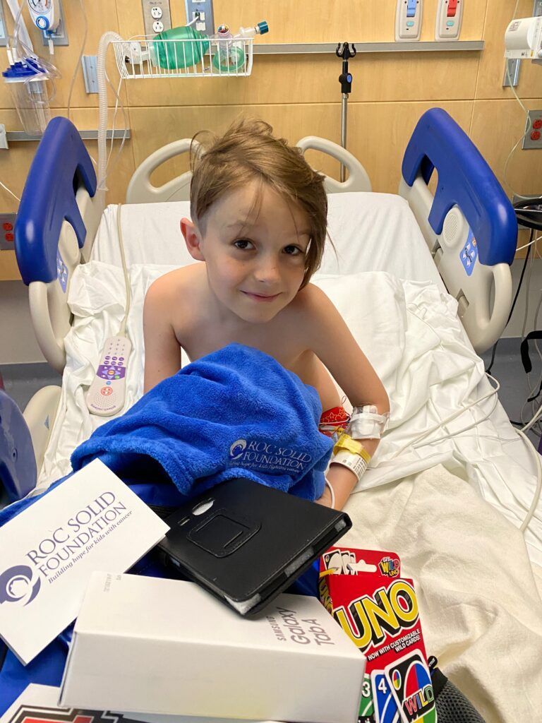 Pediatric cancer patient with his Roc Solid Ready Bag in his hospital bed.