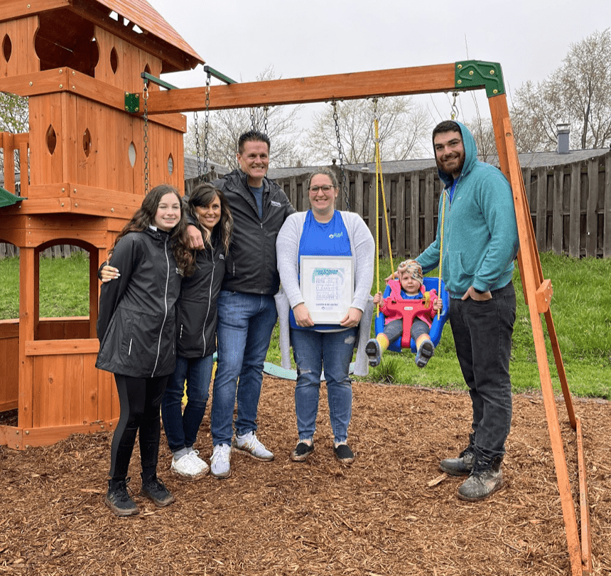 Scout and her family posing with Matt Kaulig and his family with their new playset
