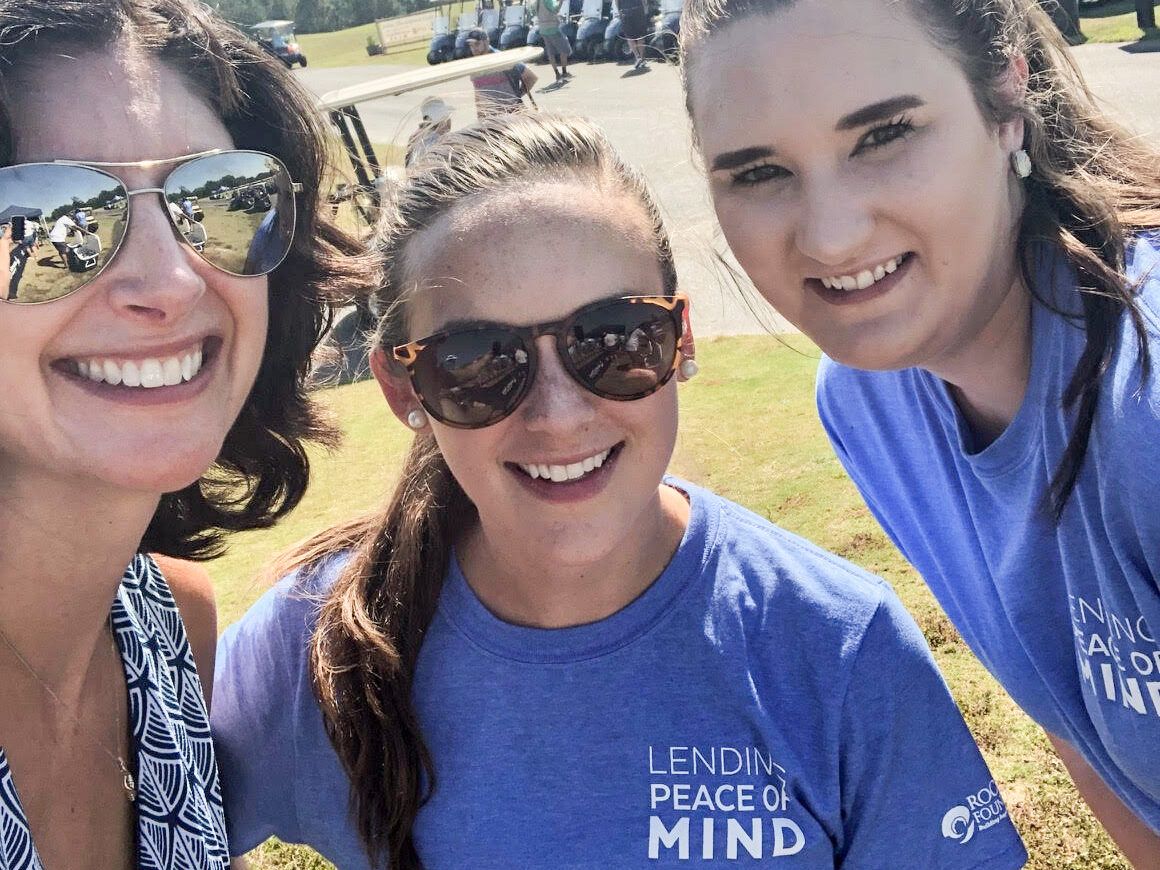 Emily and two Atlantic Bay volunteers show their support for Roc Solid at a charity golf tournament. 