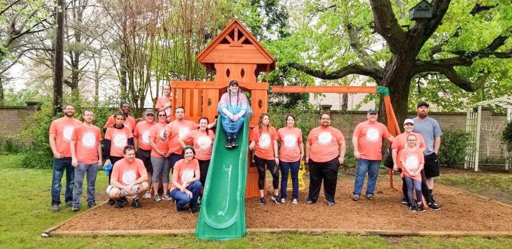 Atlantic Bay volunteers celebrate the completion of a playset project in 2019